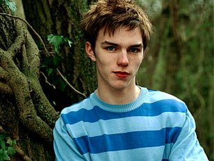 boy wearing blue crew-neck top standing near tree during daytime HD wallpaper